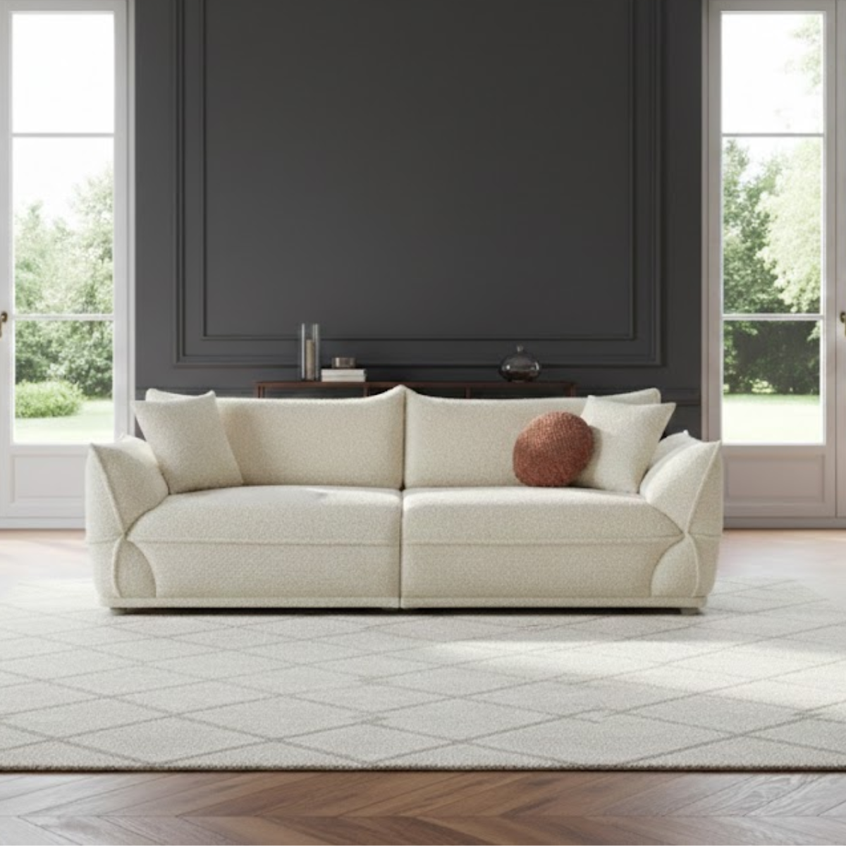 White sofa with a brown pillow in a room with large windows and dark walls.