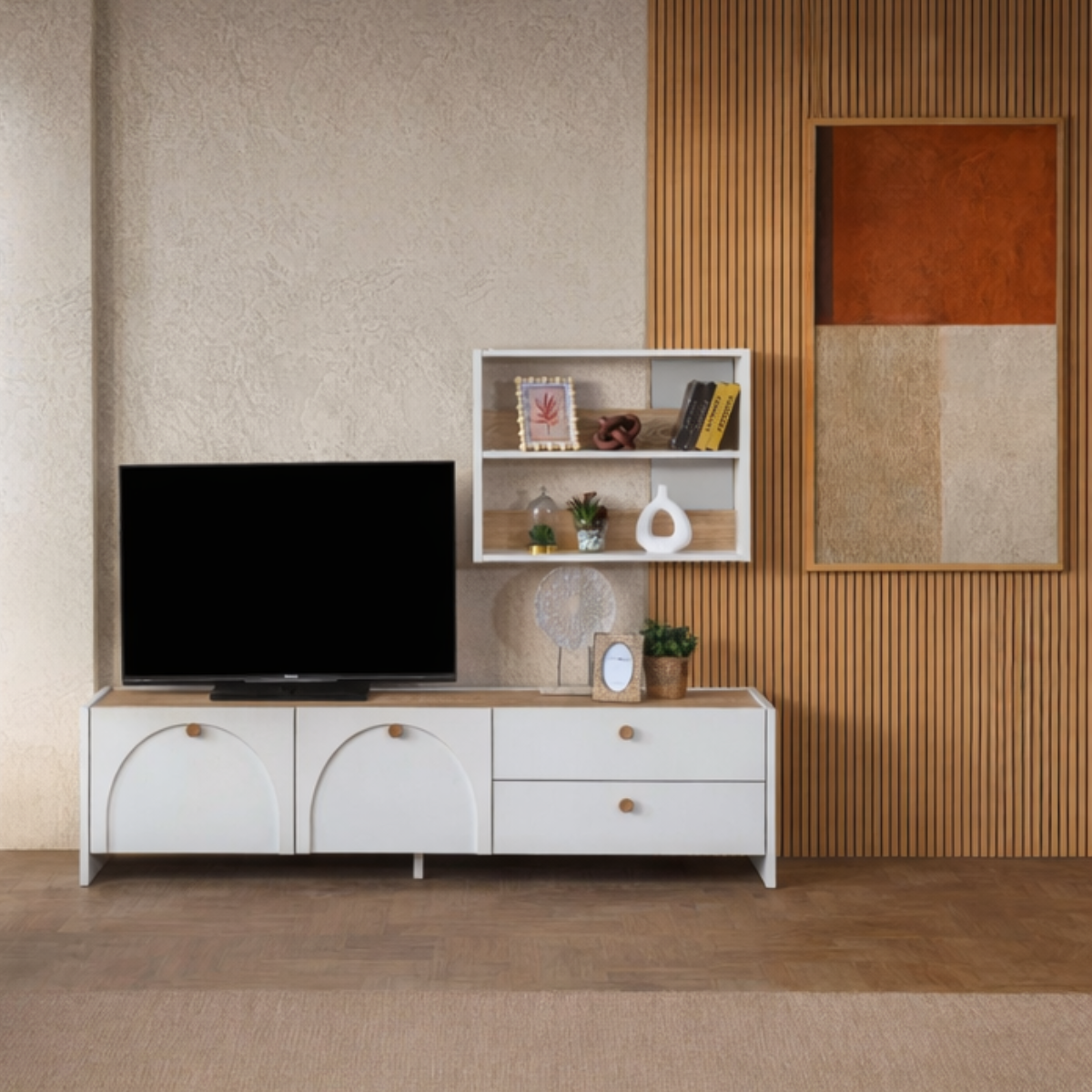 White entertainment console with TV and decorative items against a wall with wooden paneling.