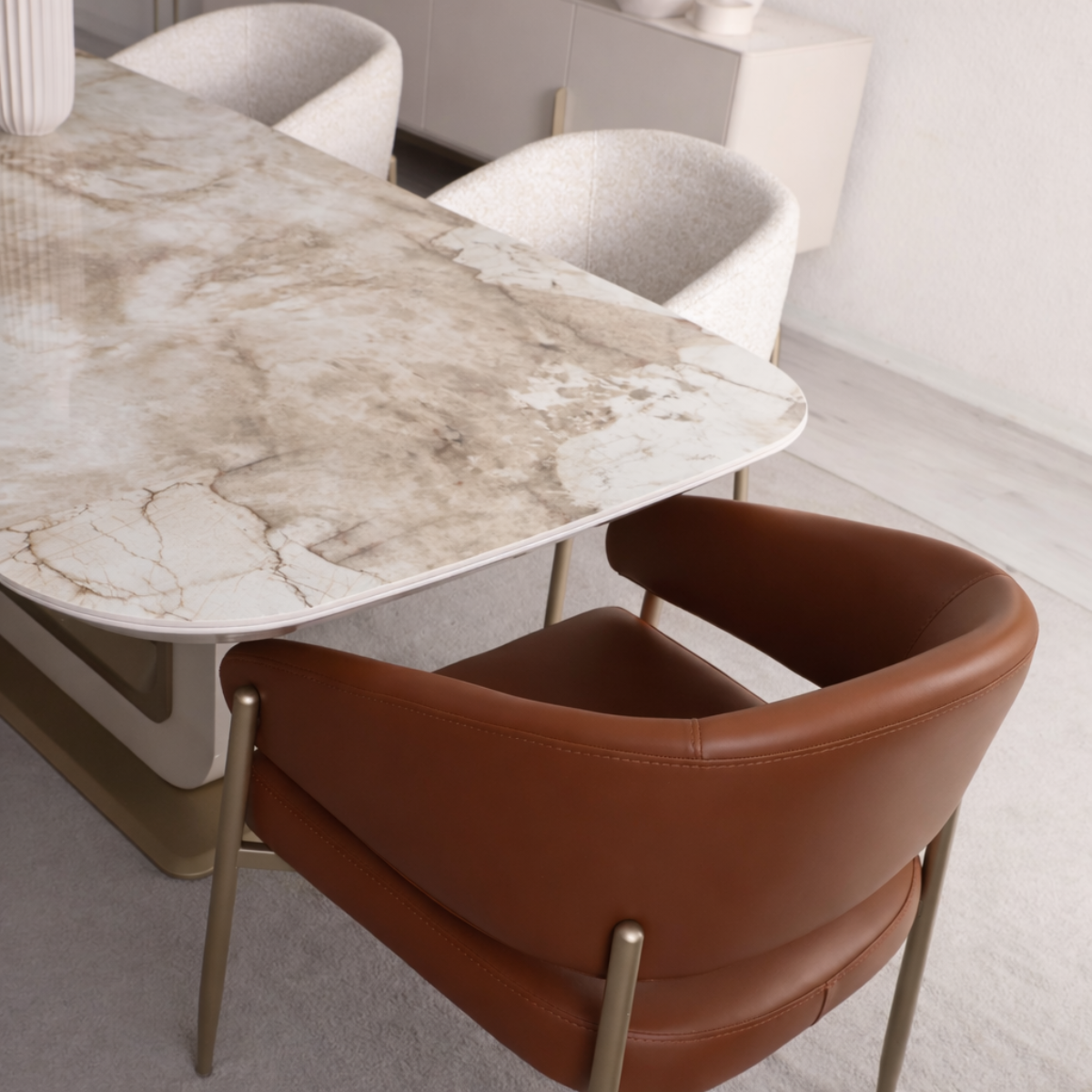 Dining table with marble surface and brown chairs in a modern interior setting