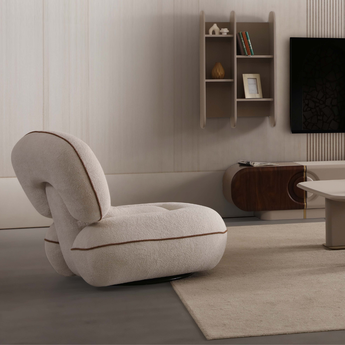 Modern living room with a beige armchair, bookshelf, and television.