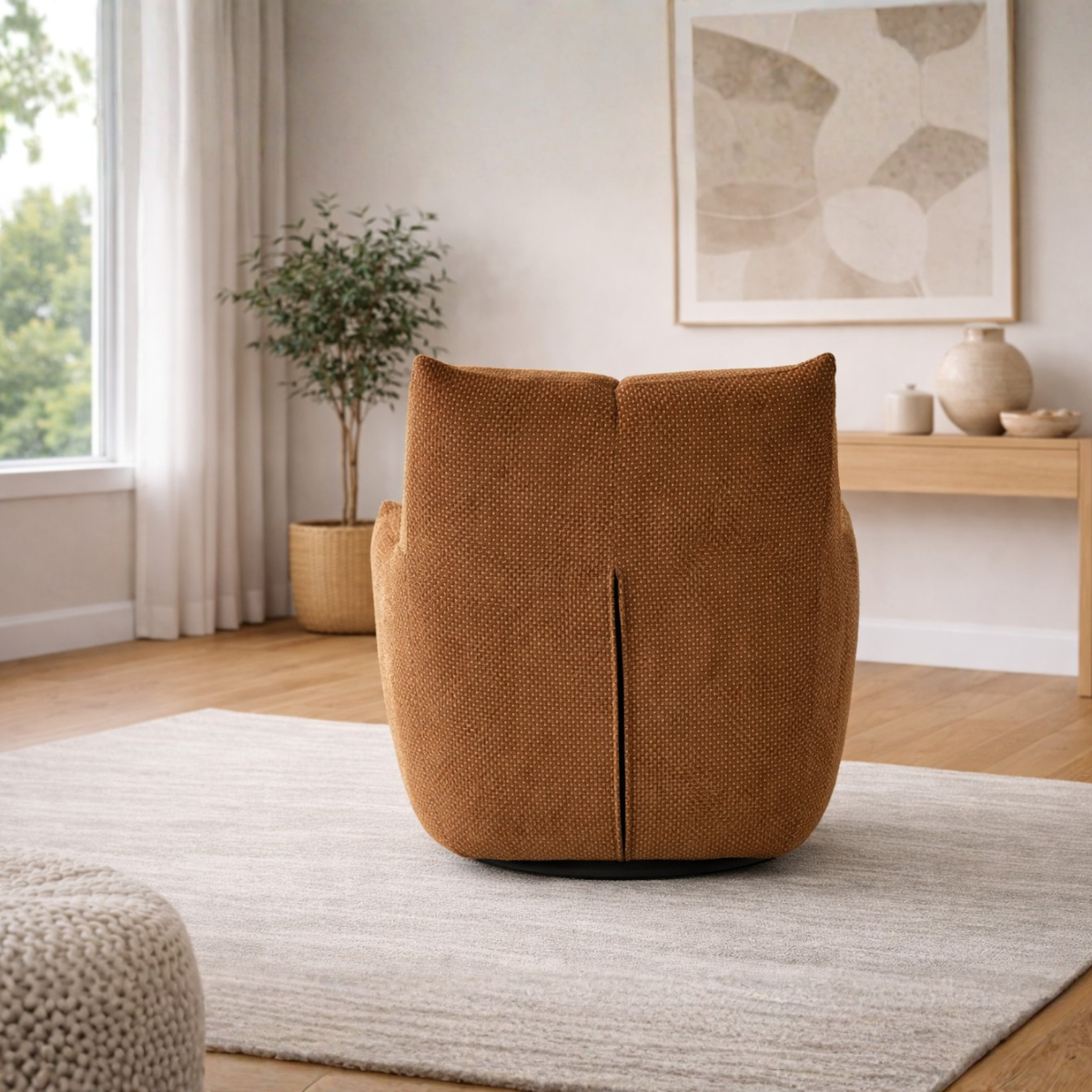 Brown textured ottoman in a living room setting with a plant and artwork on a shelf.