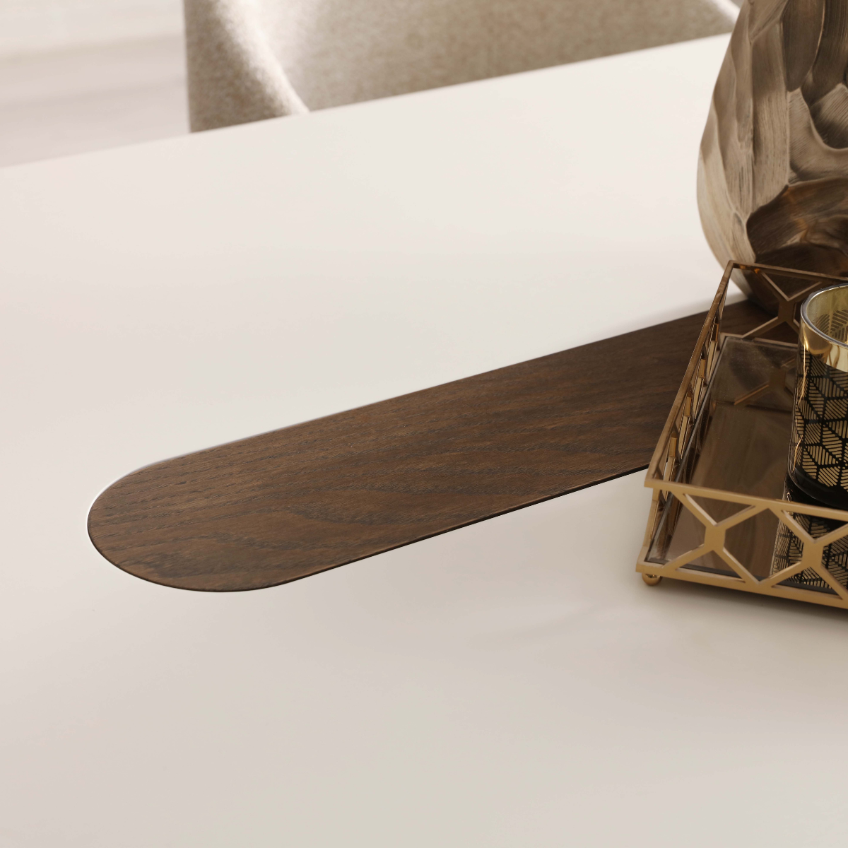 Wooden spatula on a white surface with a decorative item in the background