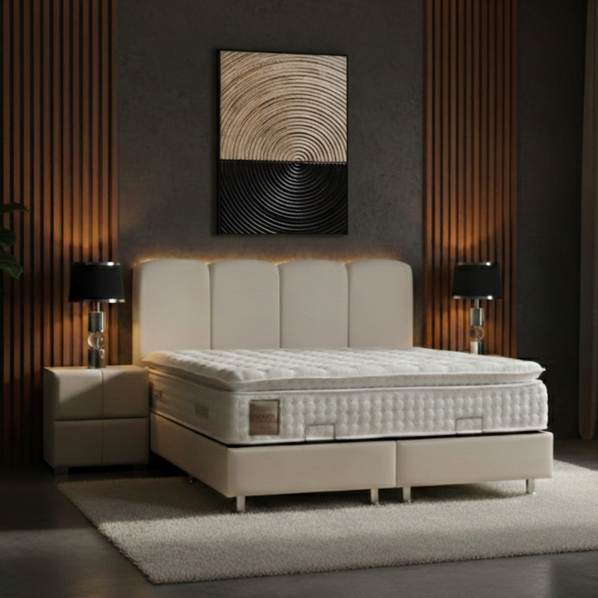 Beige bed in a modern bedroom with abstract wall art and side tables.