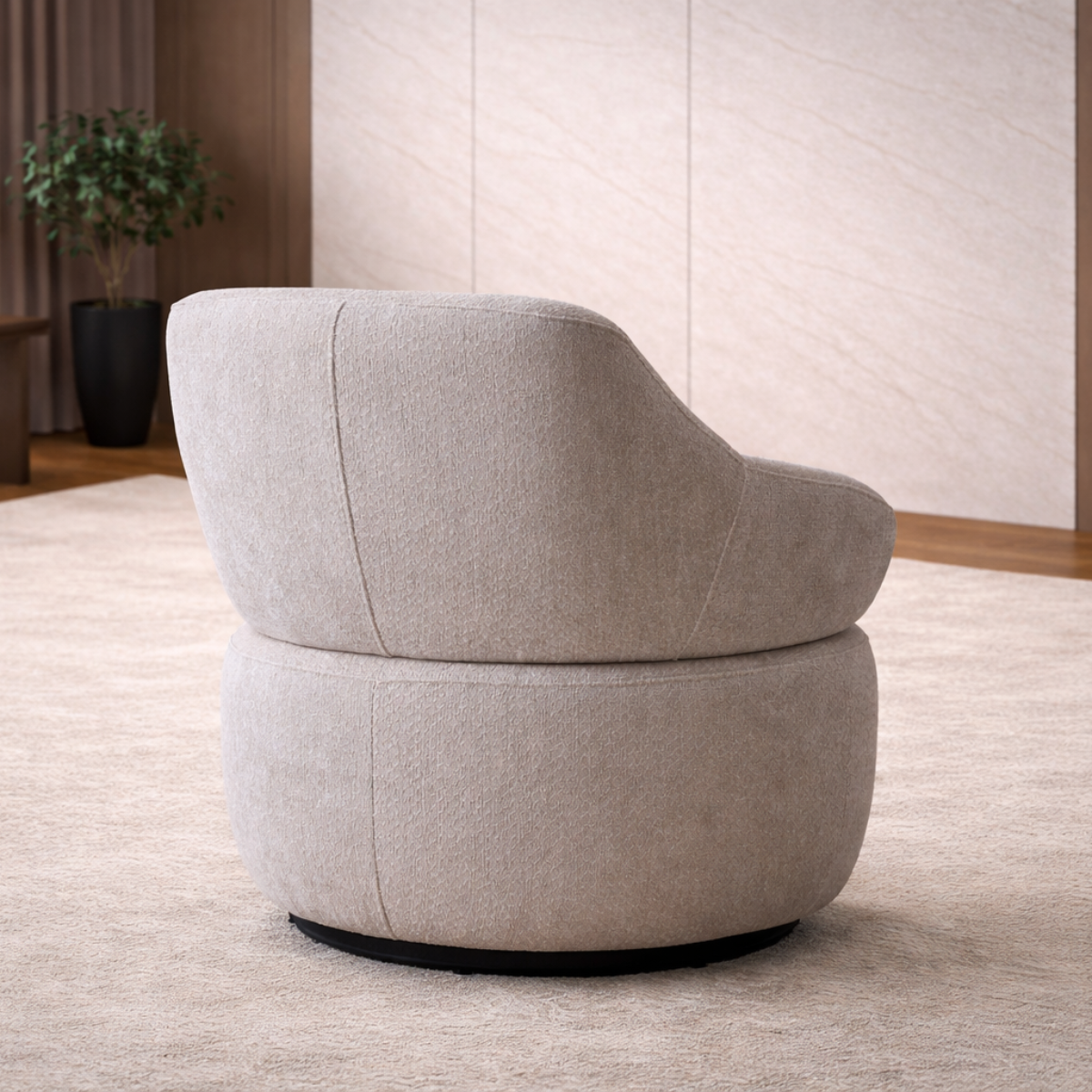Gray swivel chair in a room with a plant and light-colored walls.